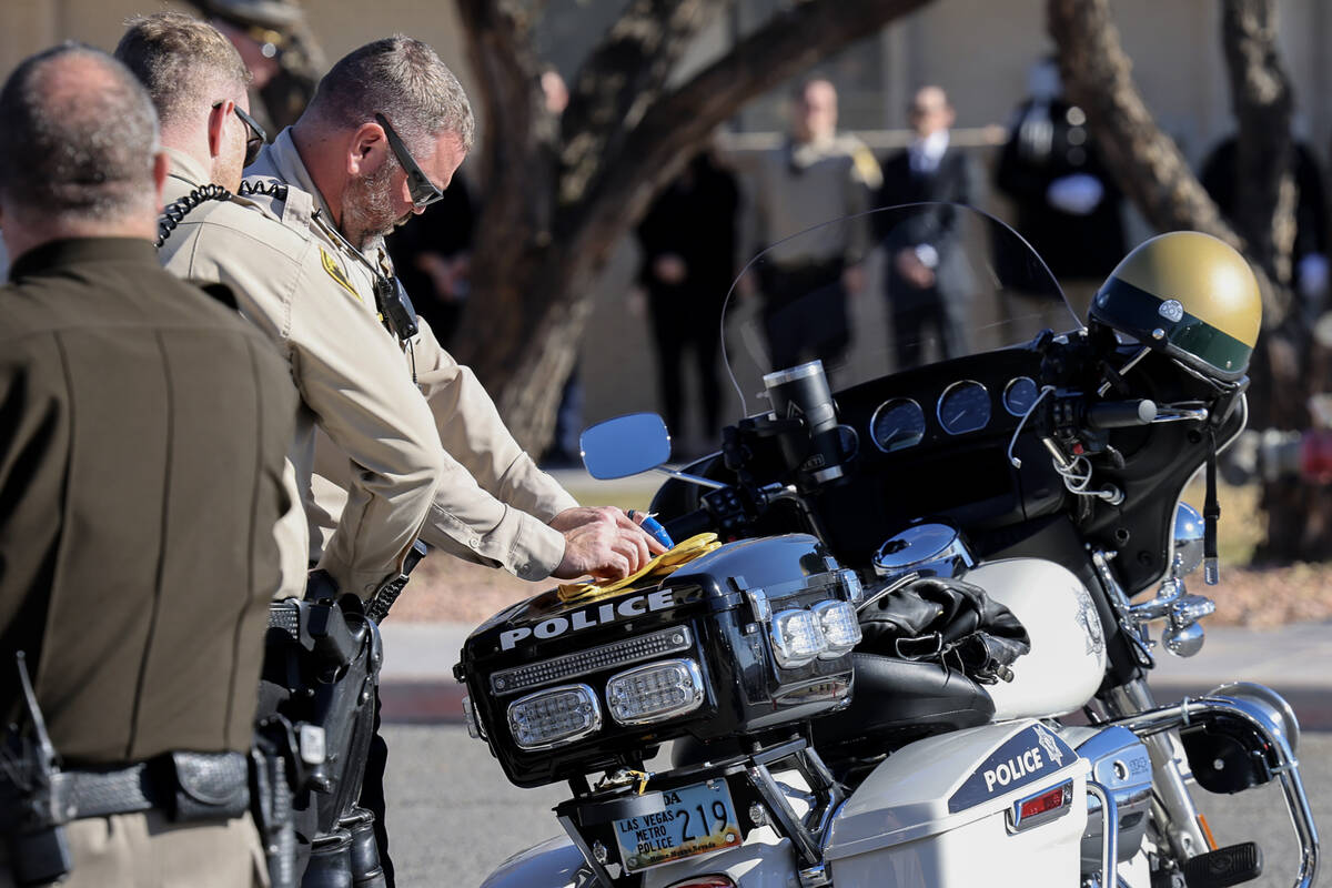 Officers place gloves on the motorcycle of Las Vegas police officer Colton Pulsipher during fun ...