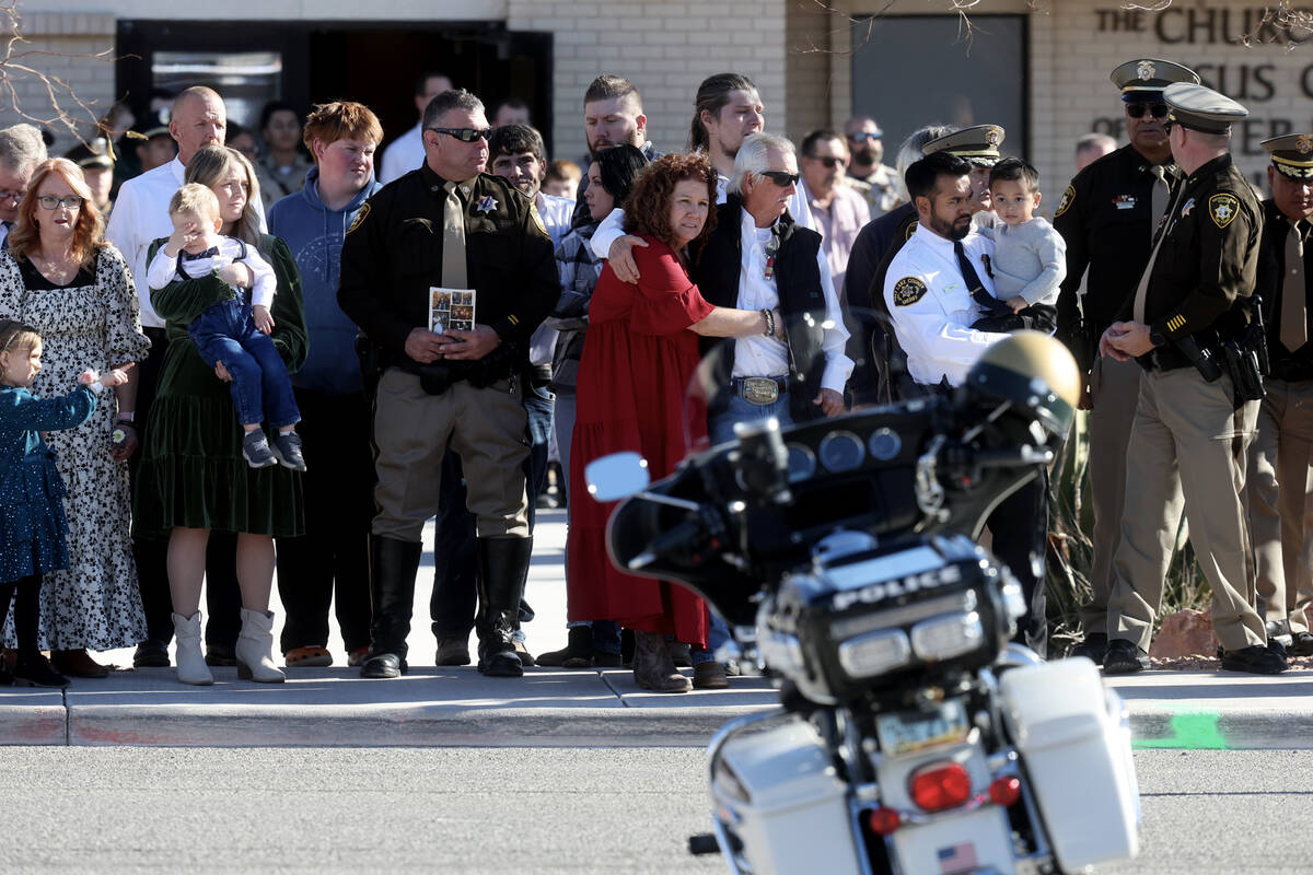 Officers and family members gather at the motorcycle of Las Vegas police officer Colton Pulsiph ...