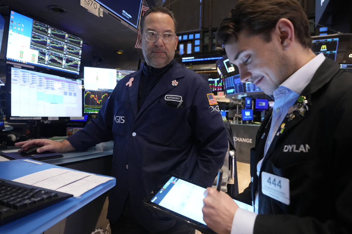 Specialist Anthony Matesic, left, works at his post on the floor of the New York Stock Exchange ...