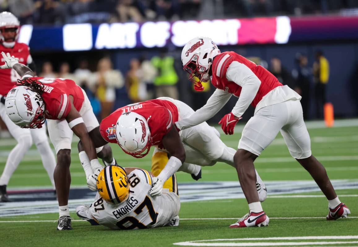 Cal tight end Jack Endries (87) gets tackled by UNLV defensive end Antonio Doyle Jr., center, a ...