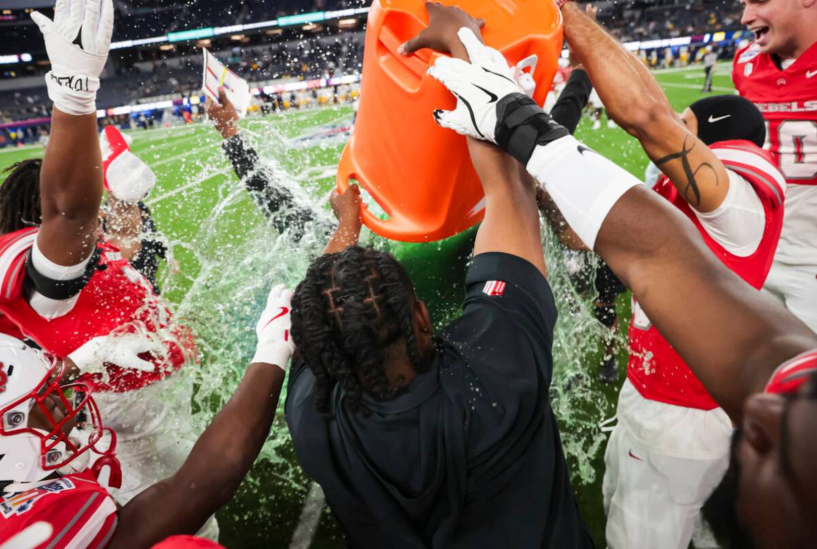 UNLV players and staff dump a bucket of gatorade onto UNLV interim head coach Del Alexander as ...