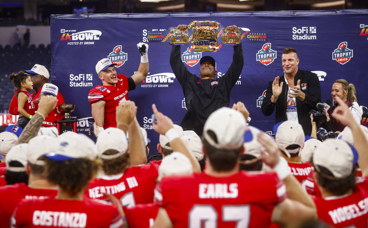 UNLV interim head coach Del Alexander lifts the trophy for the LA Bowl after the team defeated ...