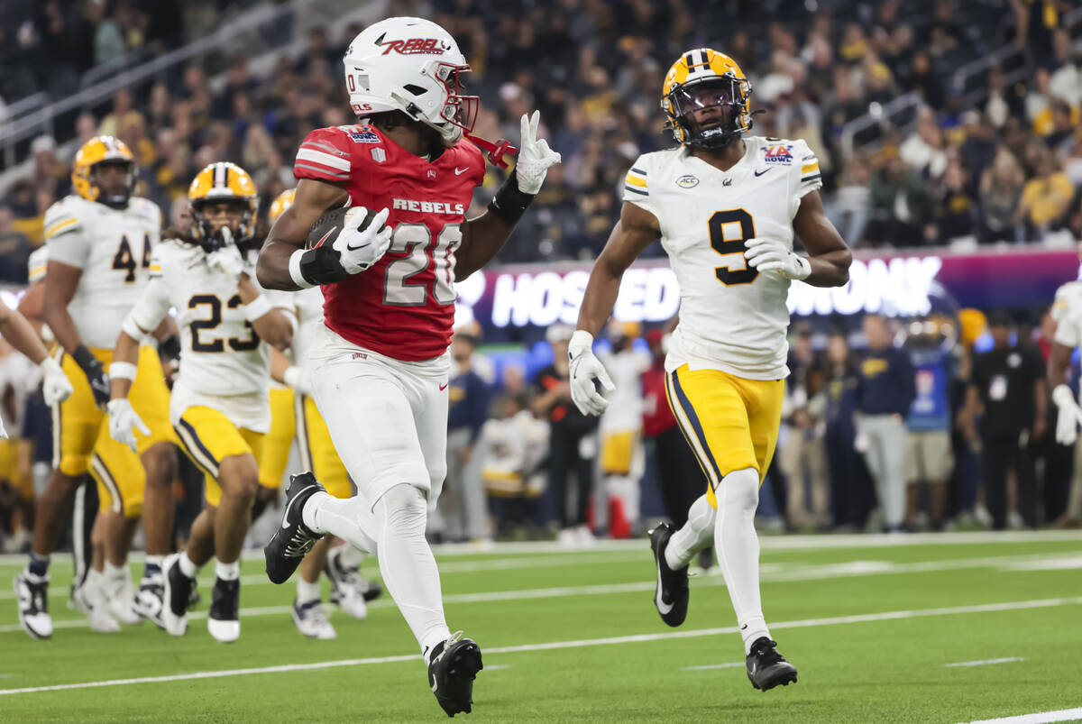 UNLV running back Kylin James (20) motions to Cal defensive back Ryan Yaites (9) on the way to ...