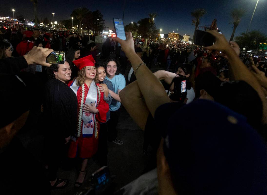 Graduates take photographs with family and friends after the UNLV winter commencement at the Th ...