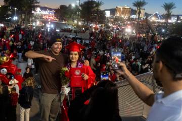 Graduates take photographs with family and friends after the UNLV winter commencement at the Th ...