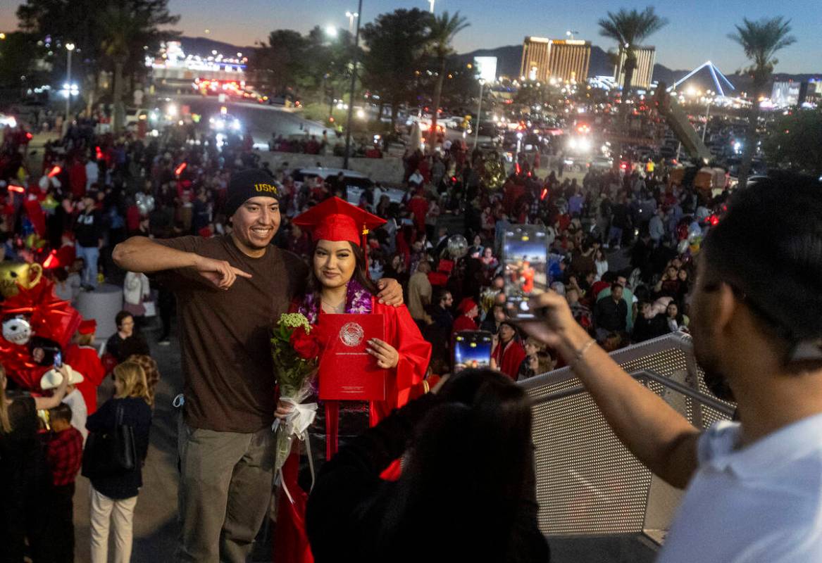 Graduates take photographs with family and friends after the UNLV winter commencement at the Th ...