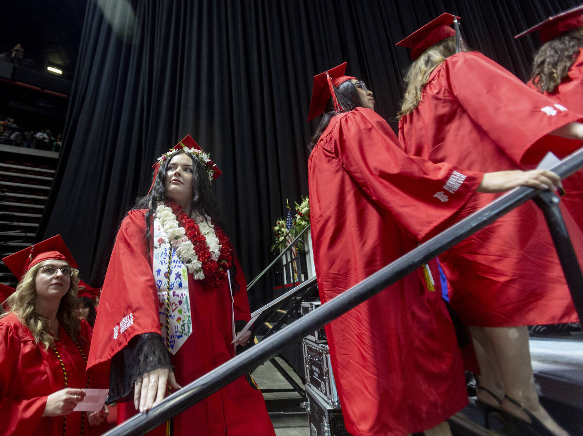 A graduate looks to the crowd before walking the stage during the UNLV winter commencement at t ...