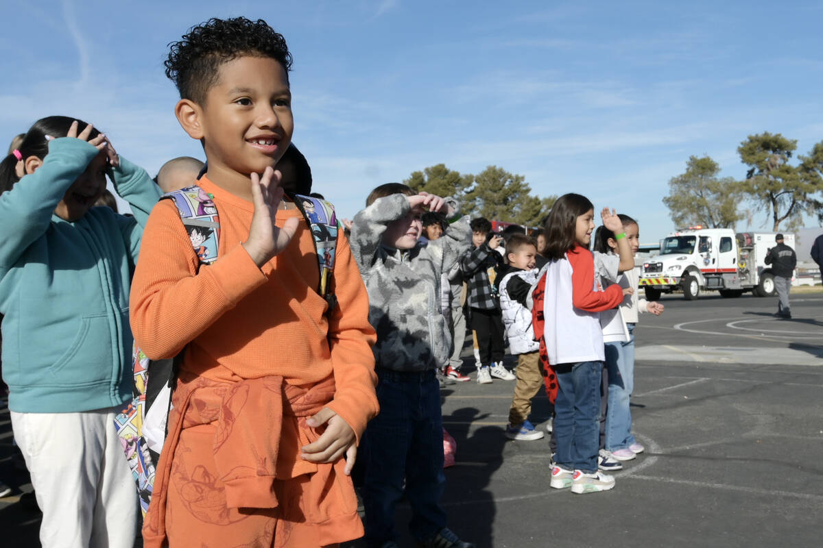 Julian Antnunez waves as firefighters arrive to deliver toys at Beckley Elementary School Thurs ...