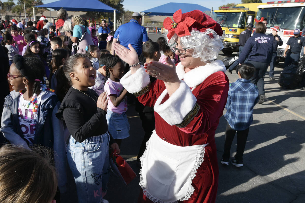 Kids react as Mrs. Claus Arrives with area firefighters to deliver toys at Beckley Elementary S ...