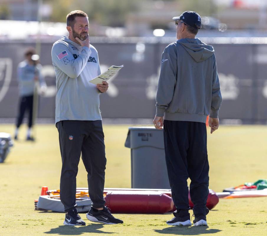 Raiders interim offensive coordinator Scott Turner, left, speaks with his father and senior off ...