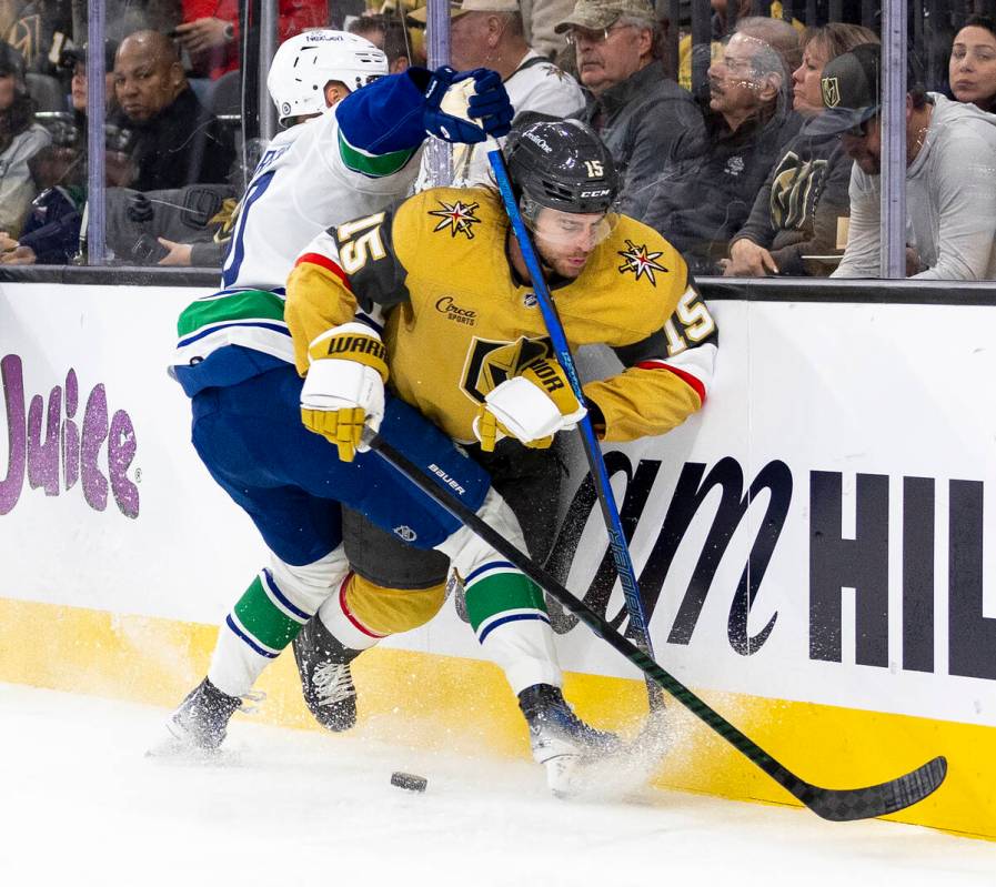 Vancouver Canucks center Elias Pettersson, left, shoves Golden Knights defenseman Noah Hanifin ...