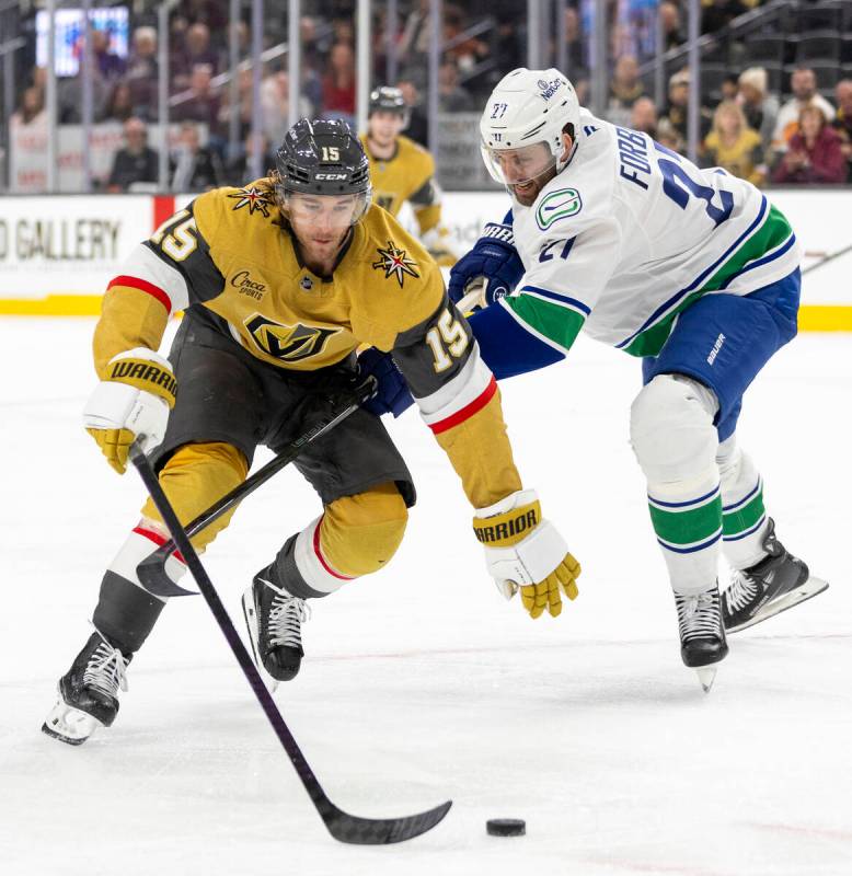 Golden Knights defenseman Noah Hanifin (15) and Vancouver Canucks defenseman Derek Forbort (27) ...