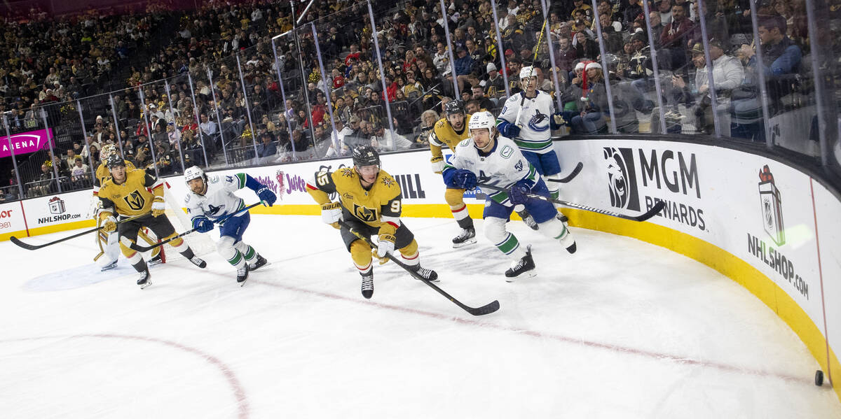 The Golden Knights and Vancouver Canucks compete for the puck during the second period of the N ...