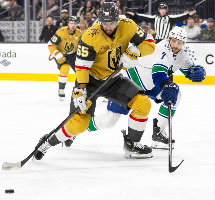 Golden Knights right wing Keegan Kolesar (55) keeps the puck from Vancouver Canucks defenseman ...