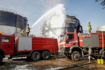 Firefighters work at the scene of an Israeli airstrike on the Haziz power station in southern S ...