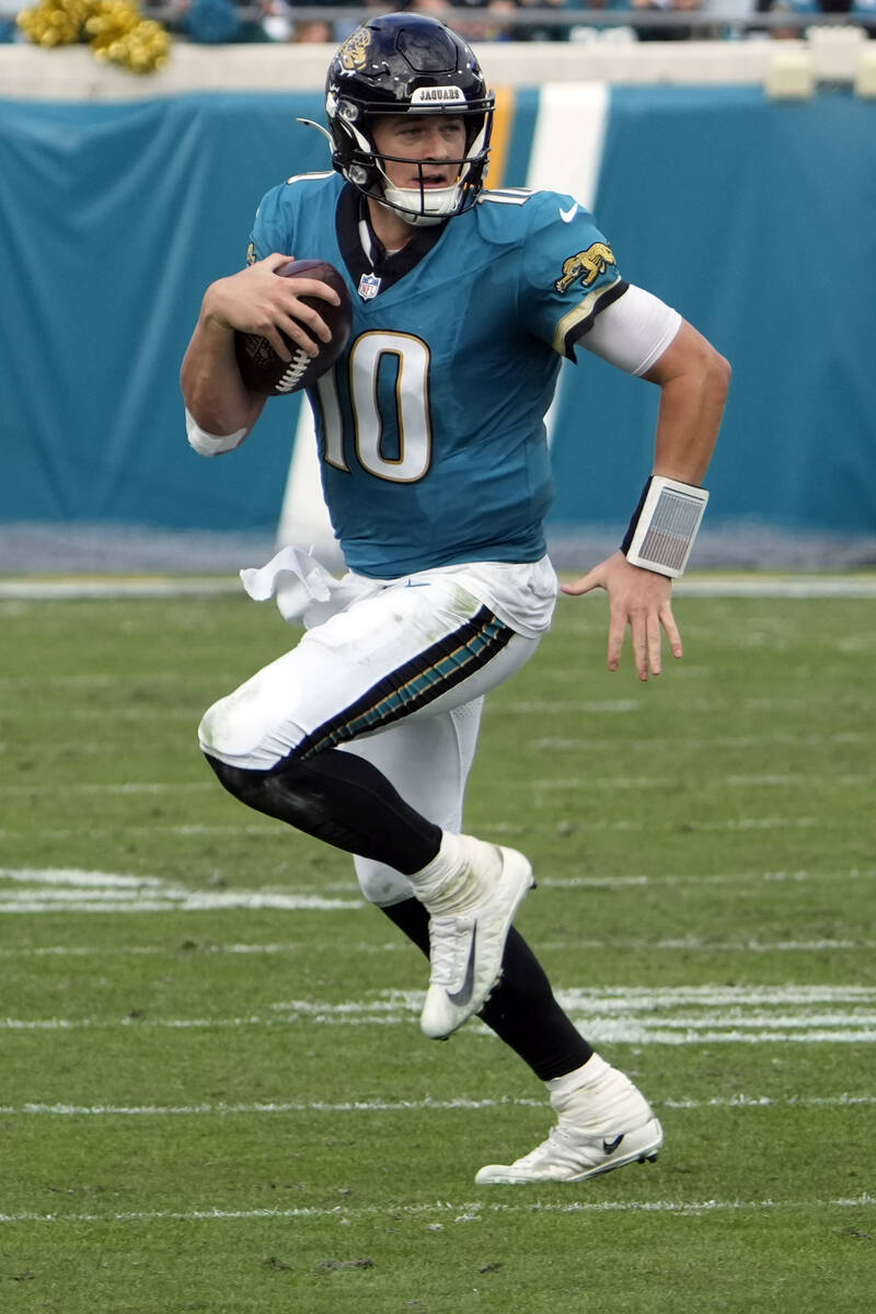 Jacksonville Jaguars quarterback Mac Jones looks for a receiver during the first half of an NFL ...