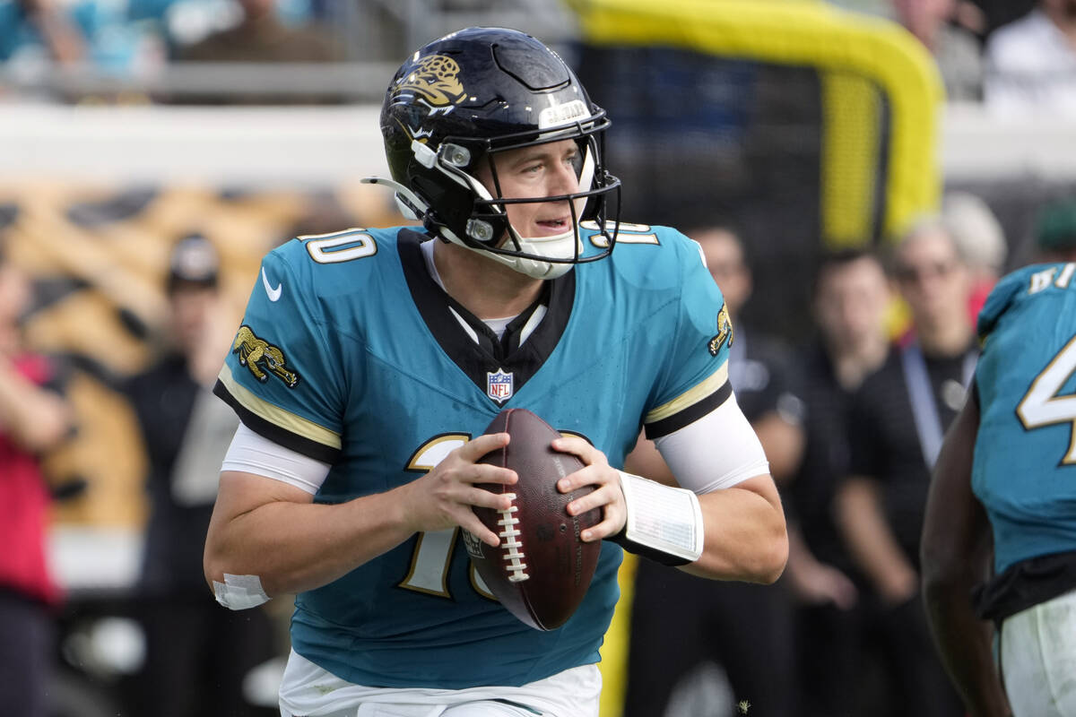 Jacksonville Jaguars quarterback Mac Jones (10) looks for a receiver during the second half of ...