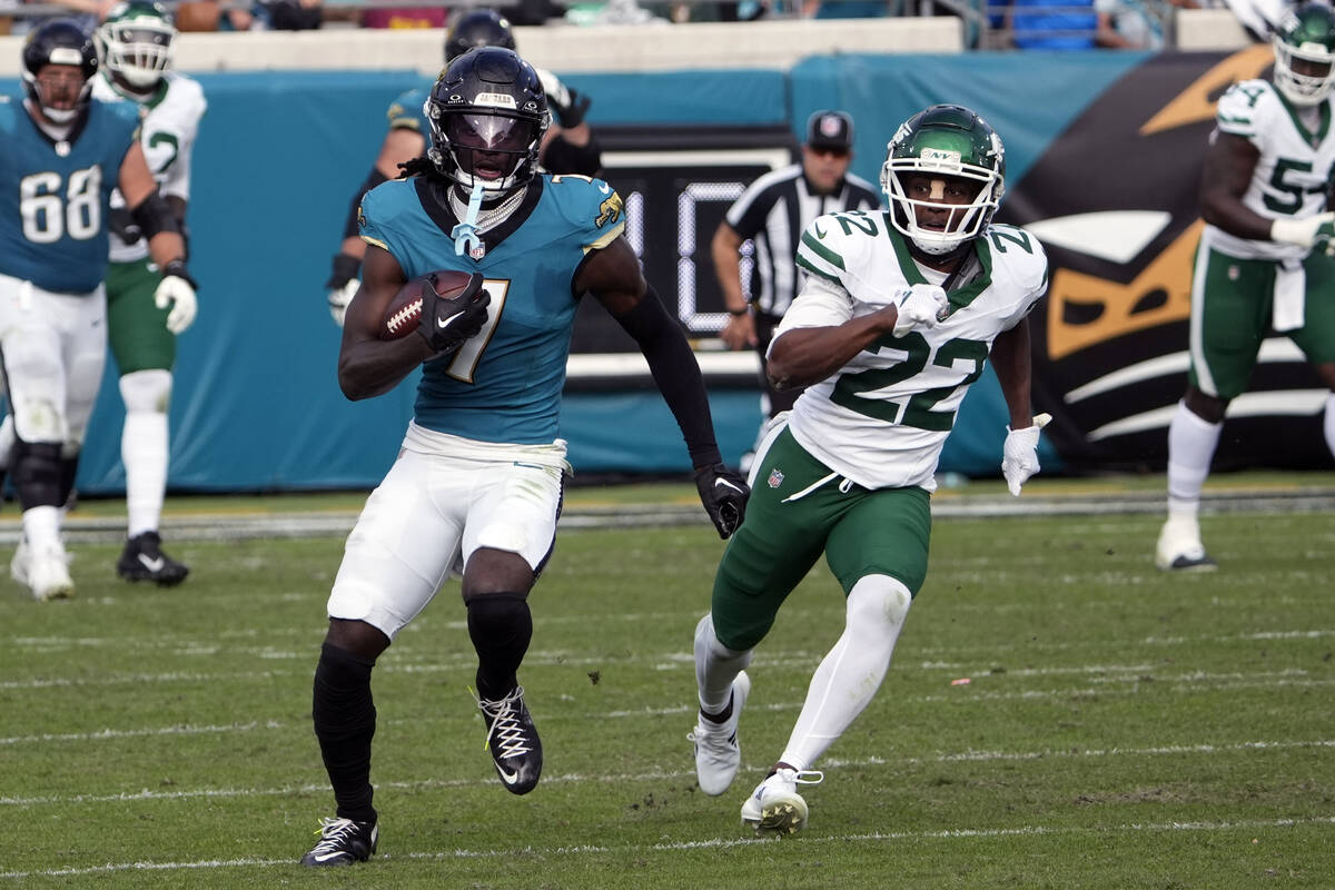 Jacksonville Jaguars wide receiver Brian Thomas Jr., left, runs past New York Jets safety Tony ...