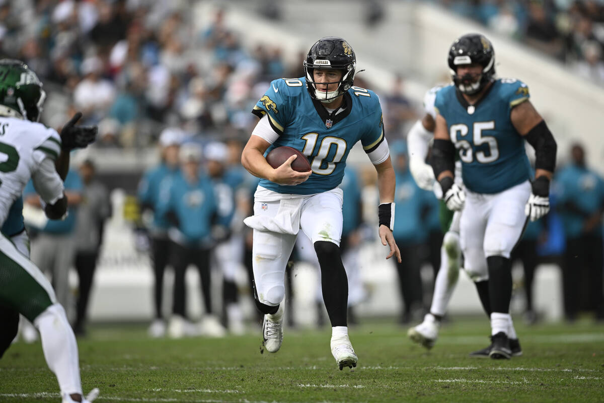 Jacksonville Jaguars quarterback Mac Jones (10) scrambles for yardage against the New York Jets ...