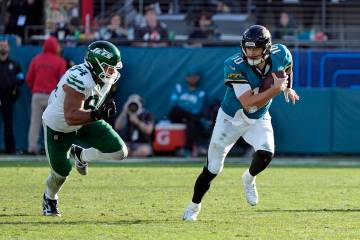 Jacksonville Jaguars quarterback Mac Jones (10) scrambles past New York Jets defensive end Solo ...