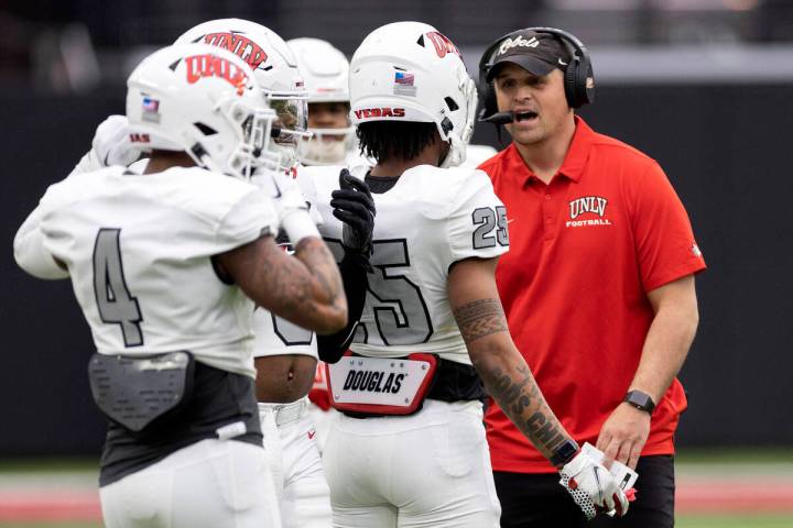 Defensive coordinator Mike Scherer communicates with defensive back Jordyn Morgan (25) during t ...