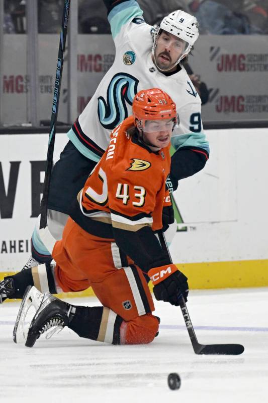 Anaheim Ducks defenseman Drew Helleson (43) and Seattle Kraken center Chandler Stephenson (9) v ...