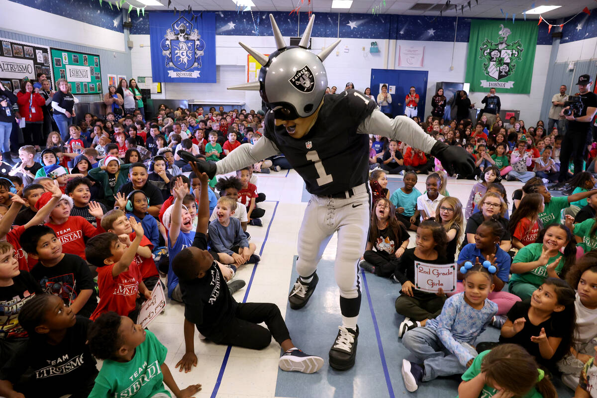 Raiders mascot Raider Rusher gets students fired up for a holiday party at Sewell Elementary Sc ...