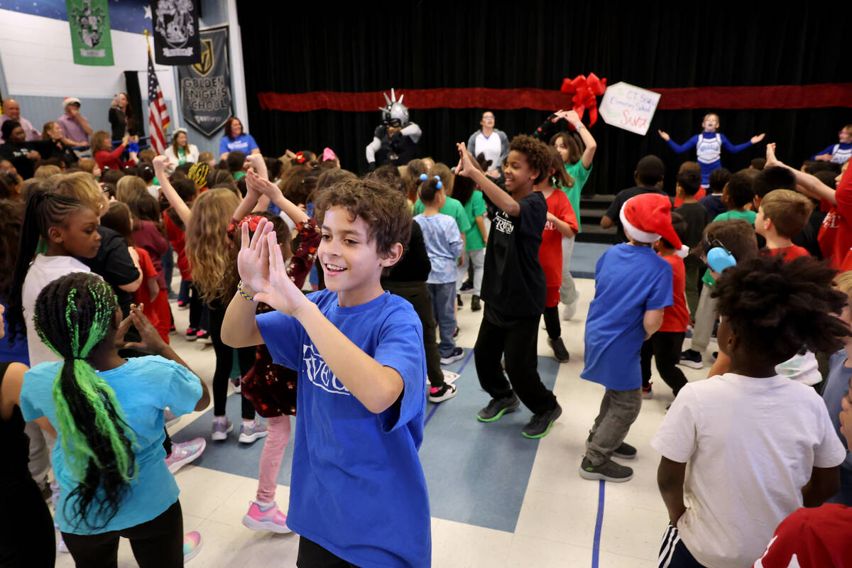 Fifth grader K’Leeyan Stevens gets fellow students fired up for a holiday party at Sewel ...