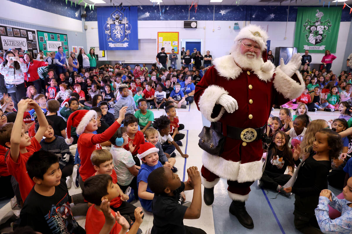 Students react to seeing Santa during a holiday party at Sewell Elementary School in Henderson ...