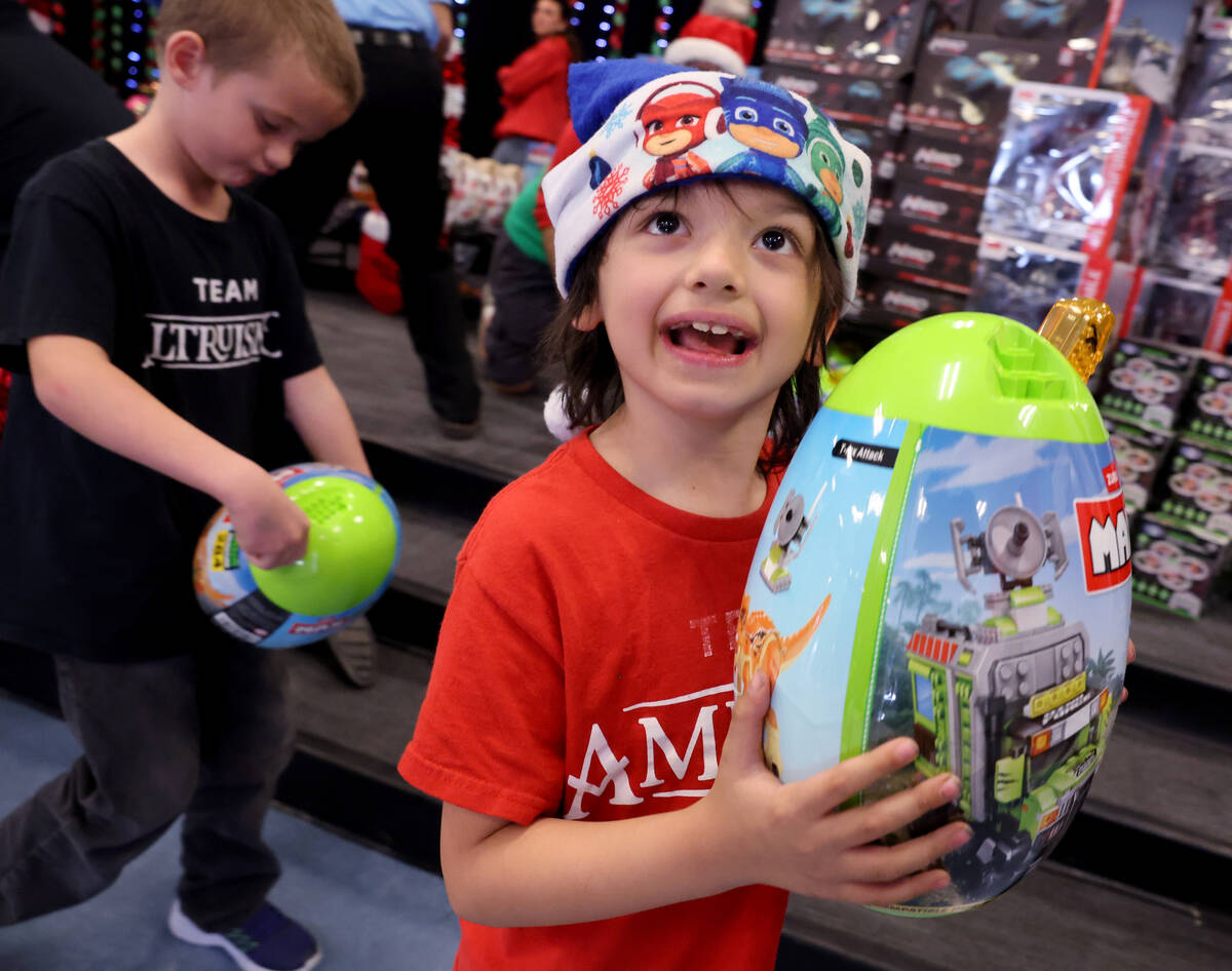 Milo Parillo receives a toy during a holiday party at Sewell Elementary School in Henderson Fri ...