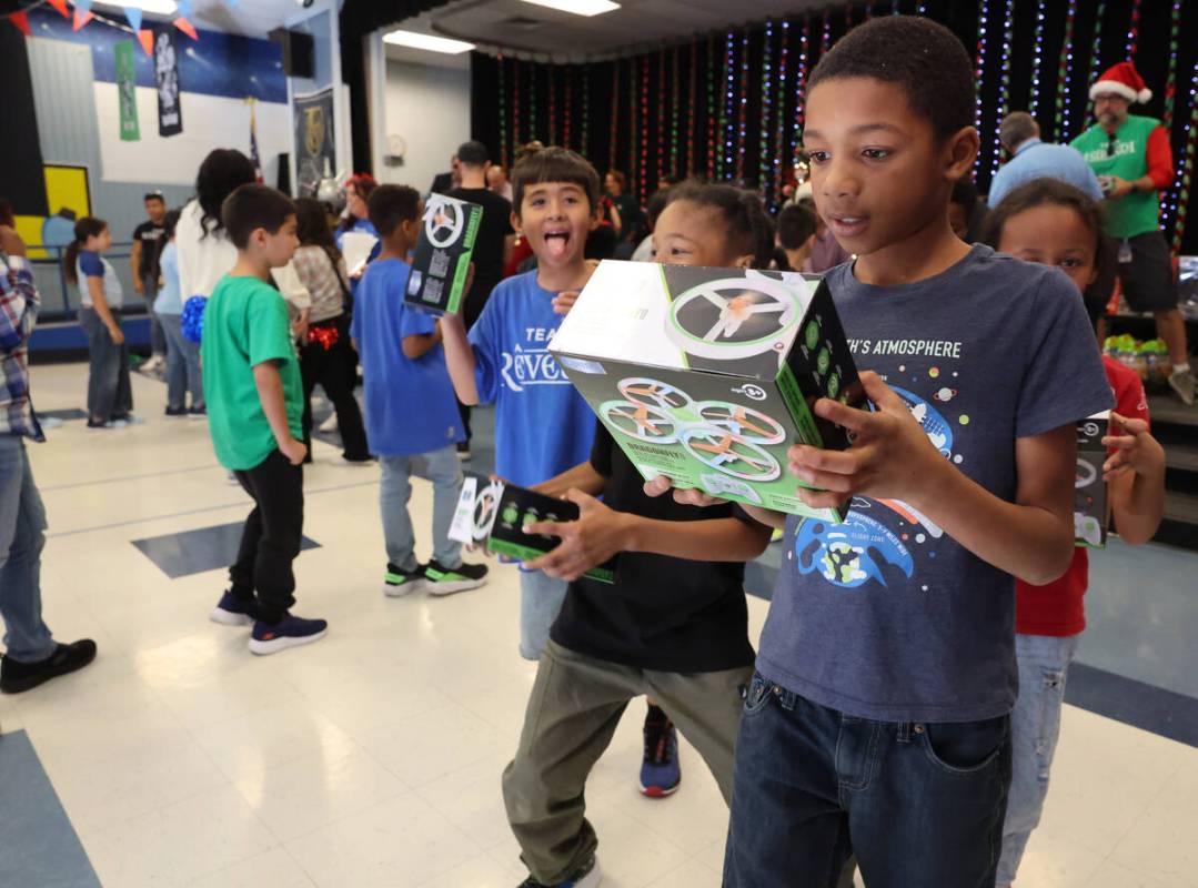 Taymir “Mr. Mack” Mack receives a toy during a holiday party at Sewell Elementary ...