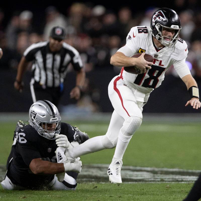 Raiders defensive tackle Jonah Laulu (96) brings down Atlanta Falcons quarterback Kirk Cousins ...