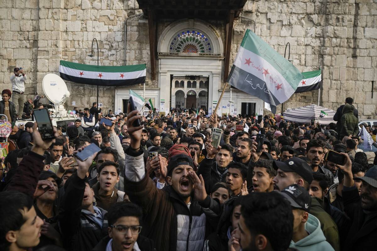 A man shouts as others wave Syrian 'revolutionary' flags in celebration after Friday prayers at ...