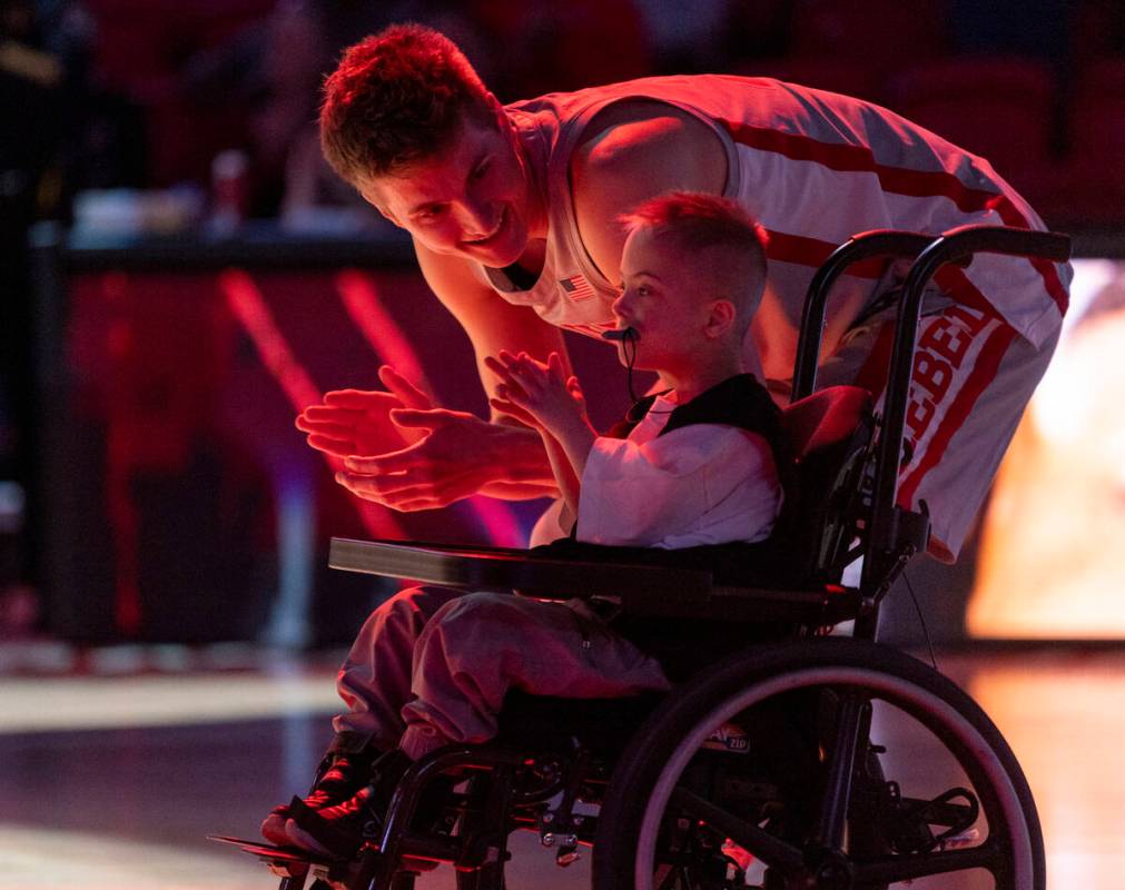 UNLV guard Julian Rishwain (20) and a member of Hoop.Camp cheer as more Runnin’ Rebel pl ...