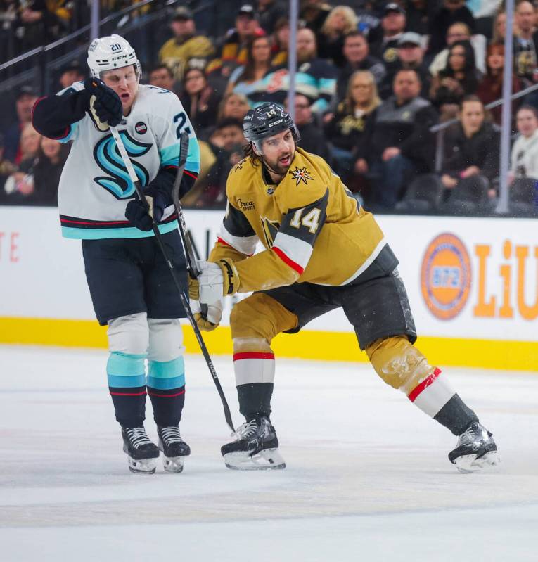 Golden Knights defenseman Nicolas Hague (14) defends Seattle Kraken right wing Eeli Tolvanen (2 ...