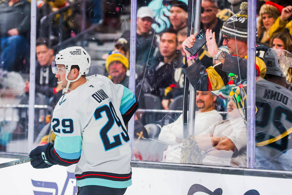 A Golden Knights fan slams the glass as Seattle Kraken defenseman Vince Dunn (29) stands near i ...