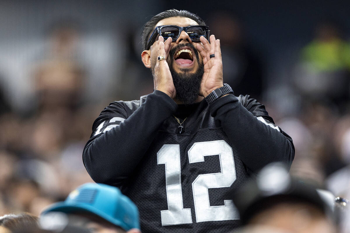 A Raiders fan cheers during the first half of the NFL game against the Jacksonville Jaguars at ...