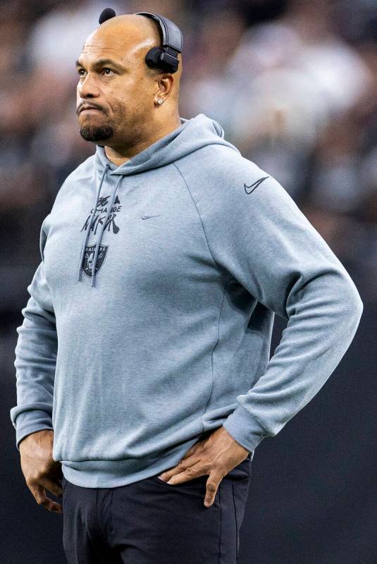 Raiders head coach Antonio Pierce watches the scoreboard during the first half of the NFL game ...