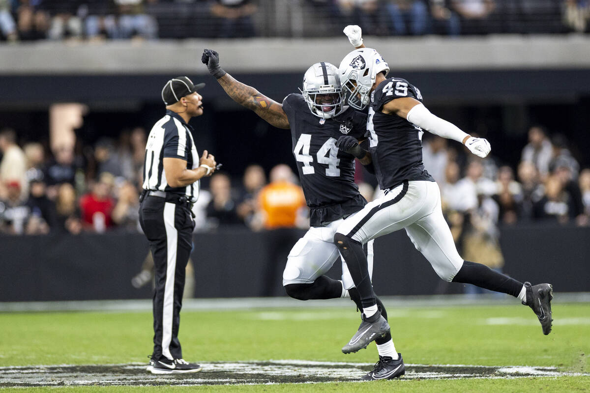 Raiders defensive end K'Lavon Chaisson (44) and Raiders defensive end Charles Snowden (49) cele ...