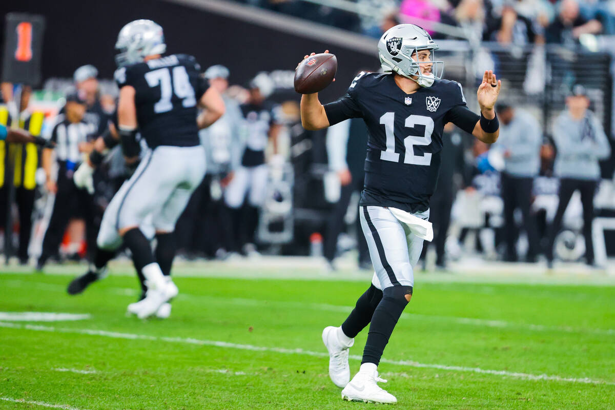 Raiders quarterback Aidan O'Connell (12) throws the ball during an NFL football game between th ...