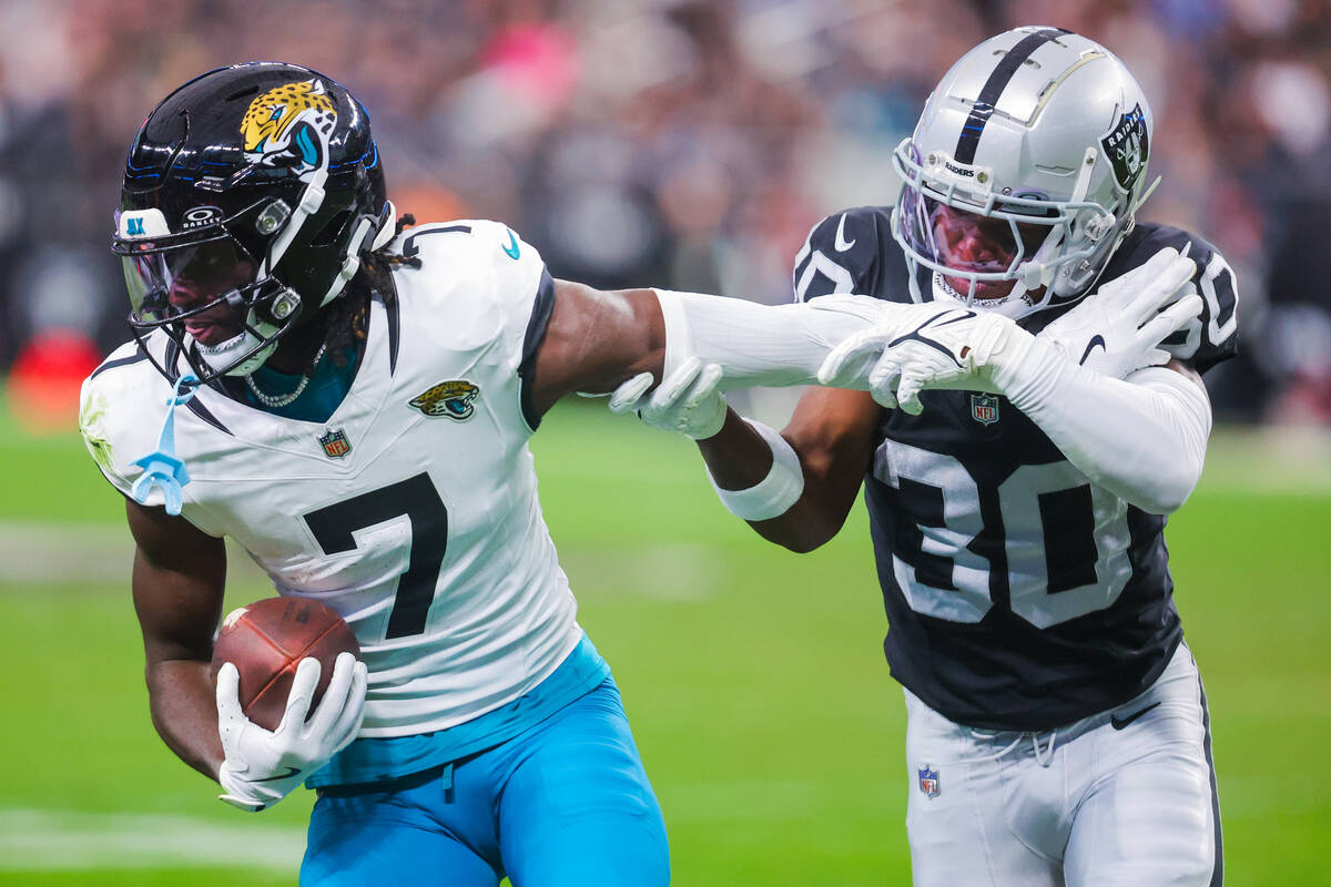 Jacksonville Jaguars wide receiver Brian Thomas Jr. (7) pushes off Raiders cornerback Darnay Ho ...