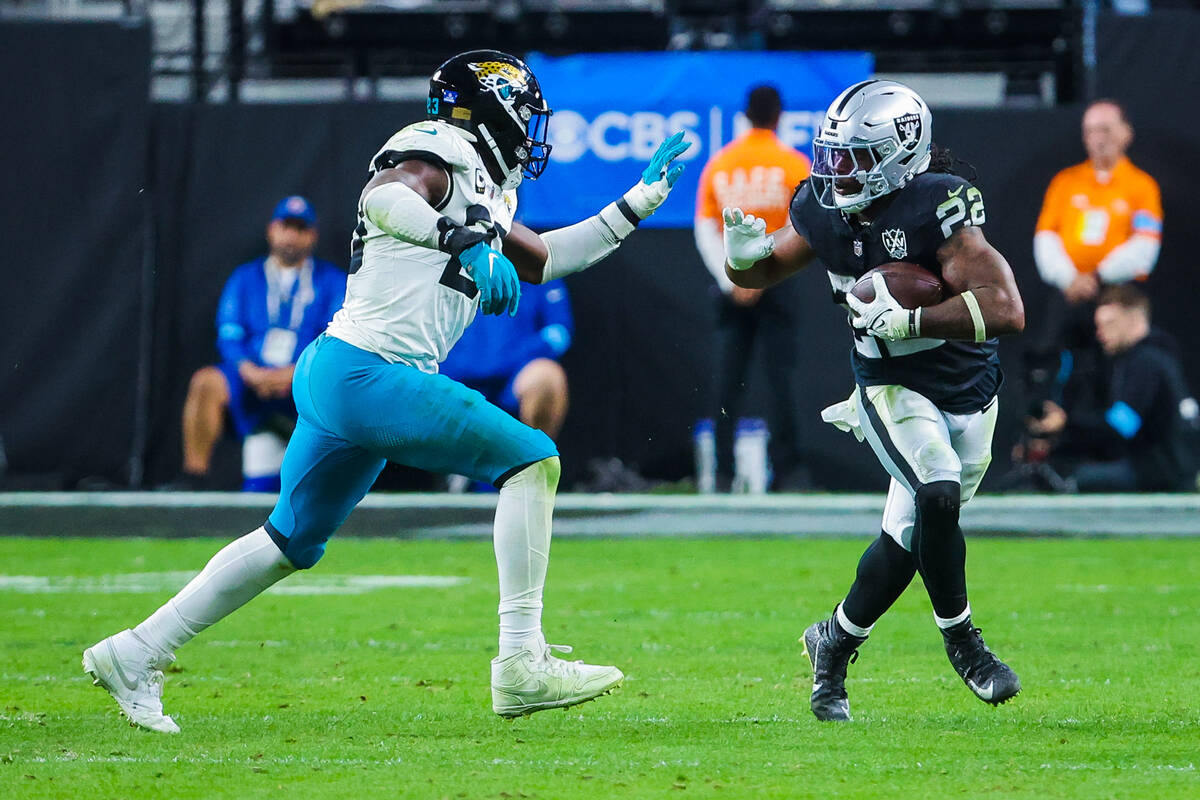 Raiders running back Alexander Mattison (22) runs the ball as Jacksonville Jaguars linebacker F ...