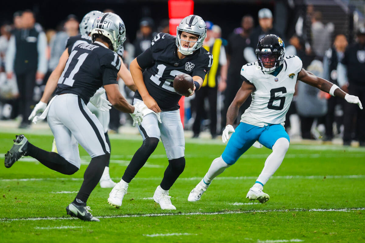 Raiders quarterback Aidan O'Connell (12) passes the ball off to Raiders wide receiver Tre Tucke ...