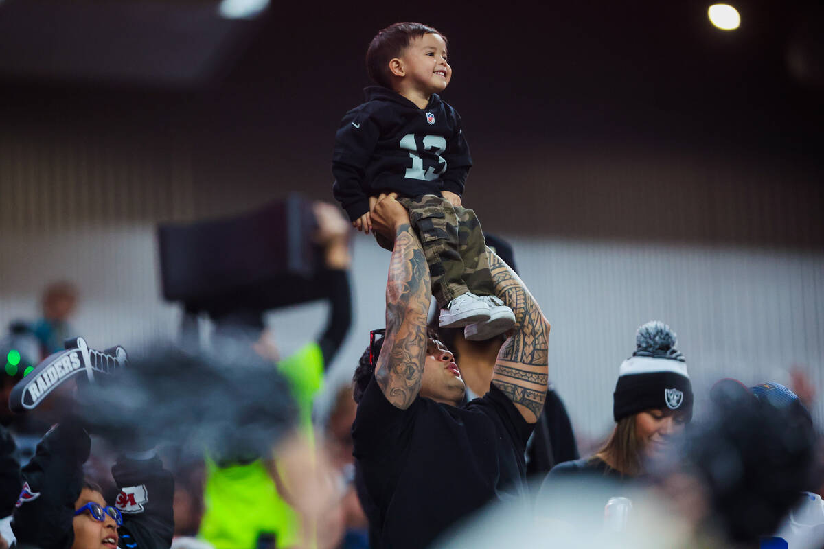 A young Raiders fan is hoisted up during an NFL football game between the Raiders and the Jacks ...