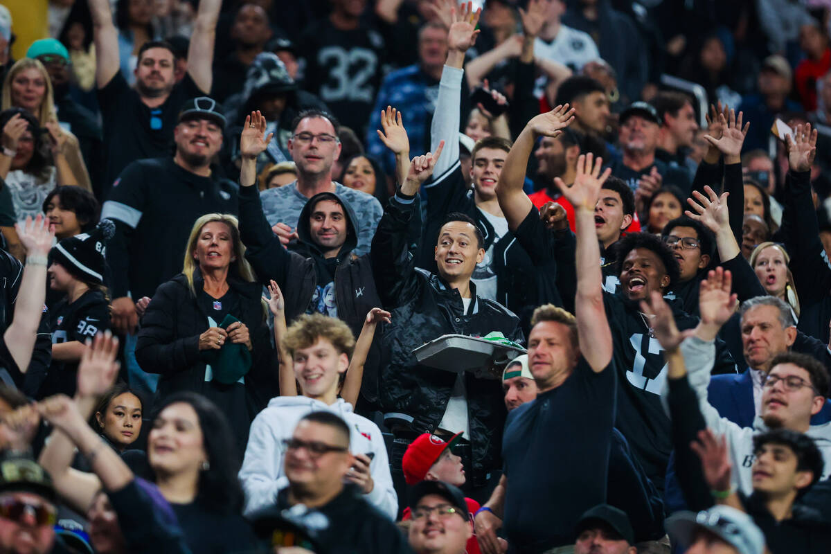 Raiders fan try to score free shirts during an NFL football game between the Raiders and the Ja ...