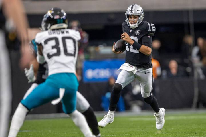 Raiders quarterback Aidan O'Connell (12) scrambles on a play during the first half of an NFL ga ...