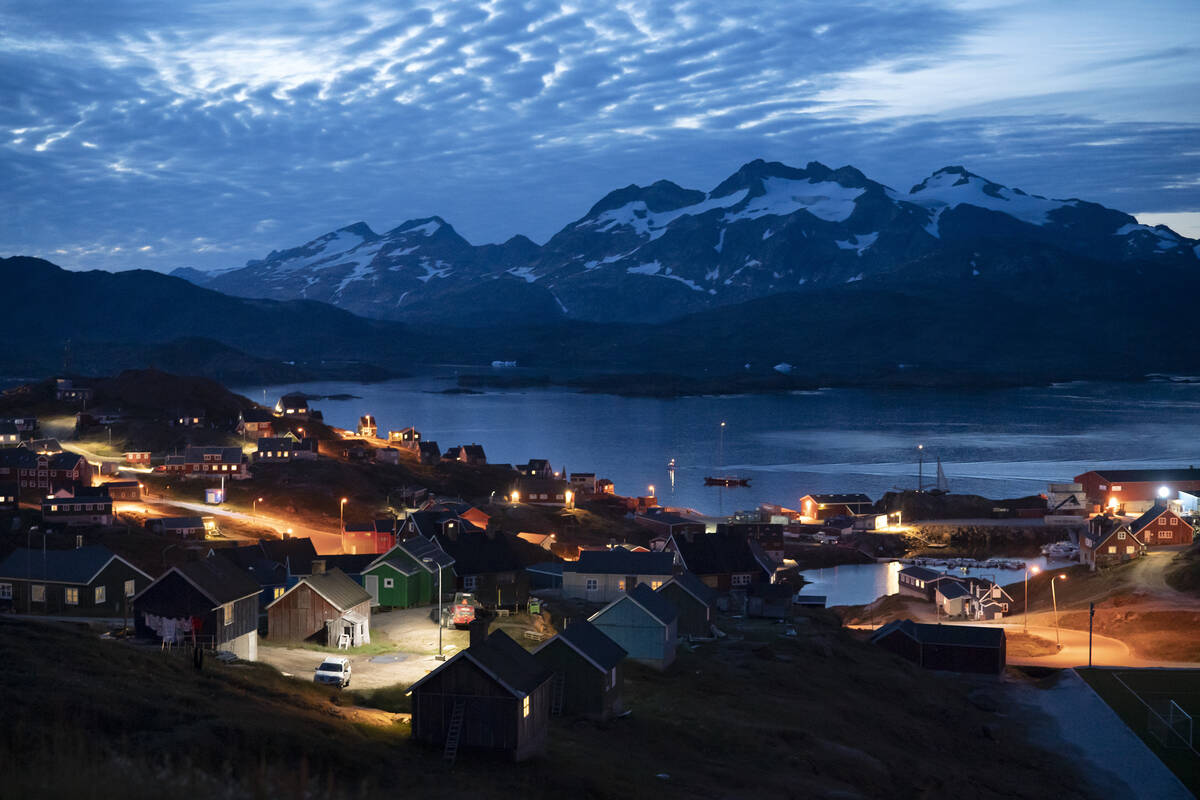 Homes are illuminated after the sunset in Tasiilaq, Greenland, Friday Aug. 16, 2019.(AP Photo/F ...