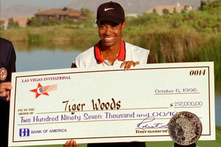 In this Oct. 6, 1996, file photo, rookie pro golfer Tiger Woods smiles after receiving a check ...