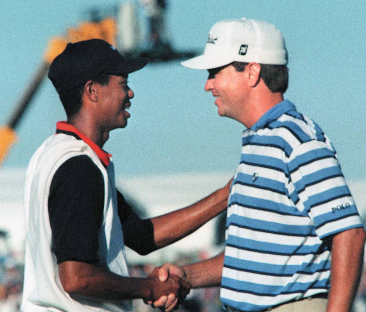 Tiger Woods shakes hands with Davis Love III after winning the Las Vegas Invitational on Oct. ...