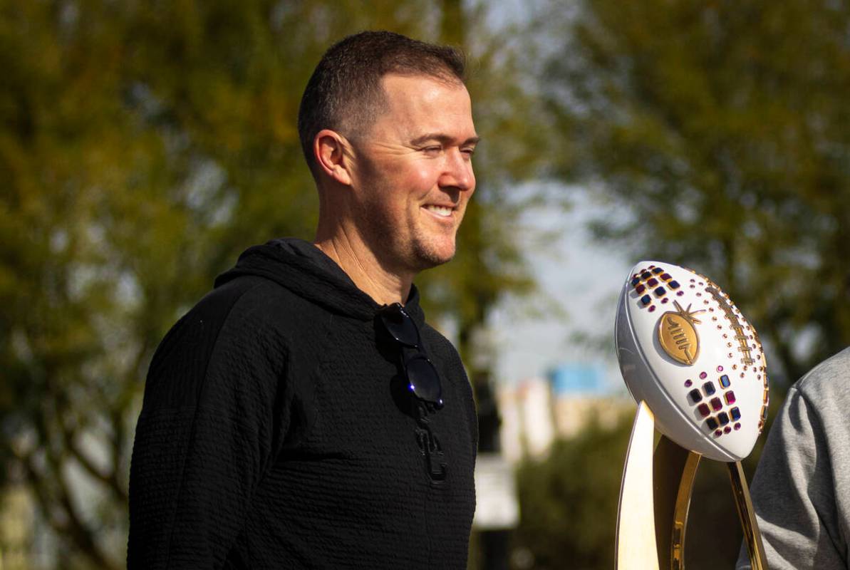 USC head coach Lincoln Riley poses for photos as his team helps out with a food drive held by t ...